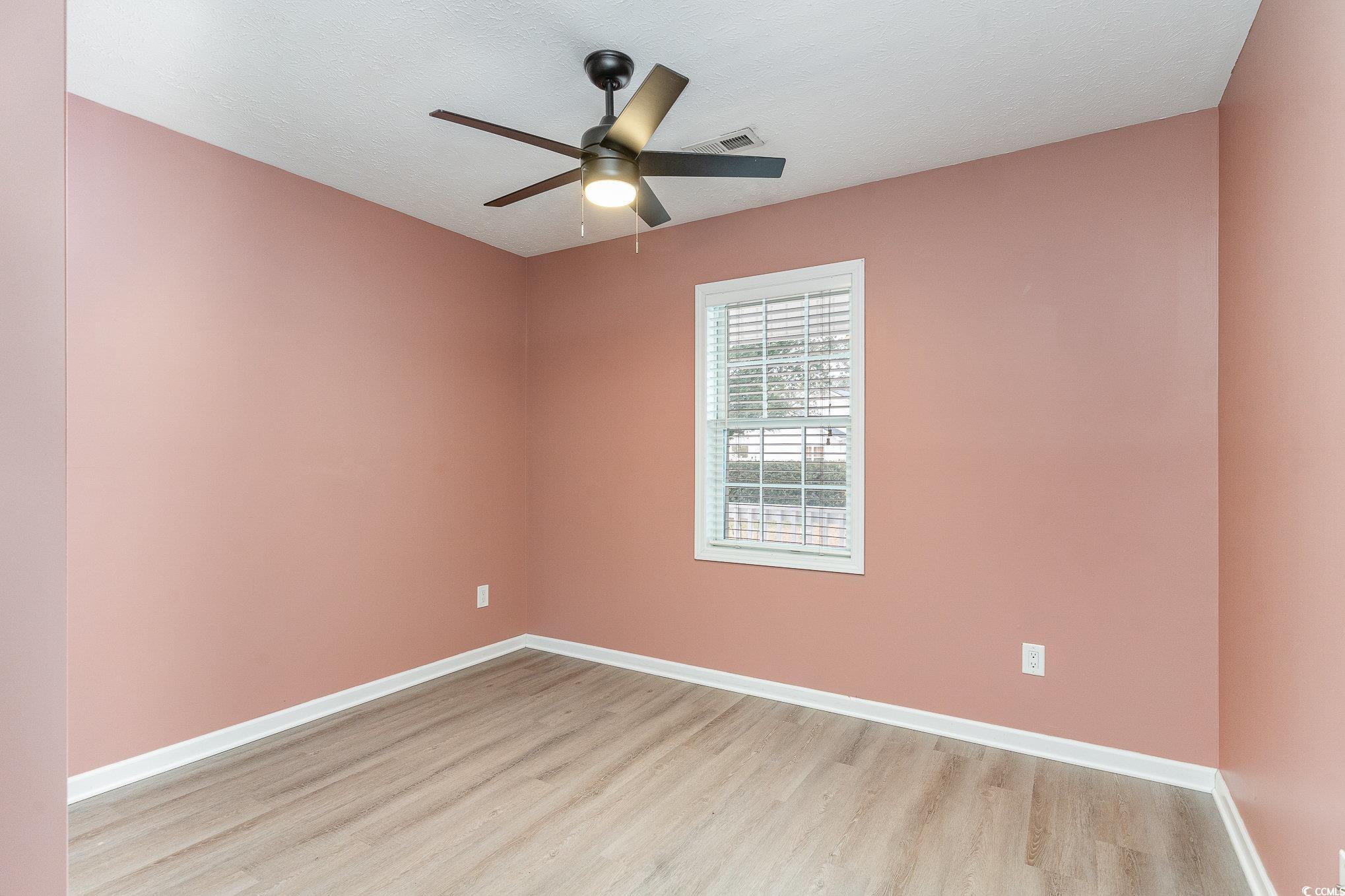 9545 Sullivan Drive Murrells Inlet, SC 29576 - Photo 8 of 30 Empty room with ceiling fan, light hardwood / wood