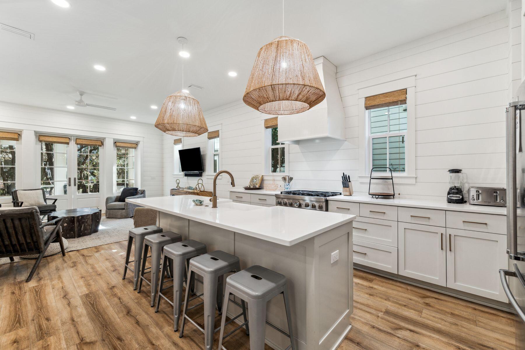 207 Anchor Rode Circle Santa Rosa Beach, FL 32459 - Photo 3 of 44 a kitchen with lots of counter space a sink dishwasher a dining table and chairs with wooden floor