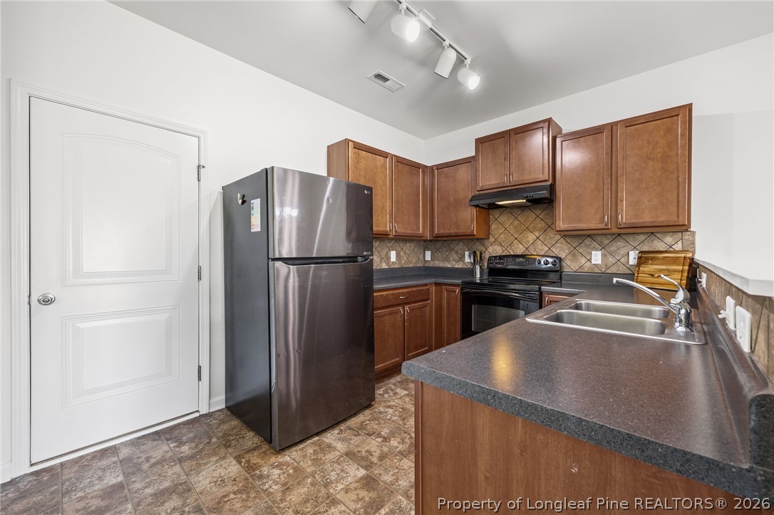 226 River Oak Street Spring Lake, NC 28390 - Photo 15 of 41 a kitchen with stainless steel appliances granite countertop a refrigerator a stove and a sink