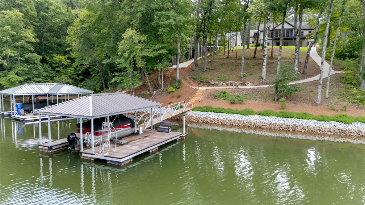 329 High Hampton Road Salem, SC 29676 - Photo 2 of 47 A private covered dock sits on the water with a paved pathway leading to the home.