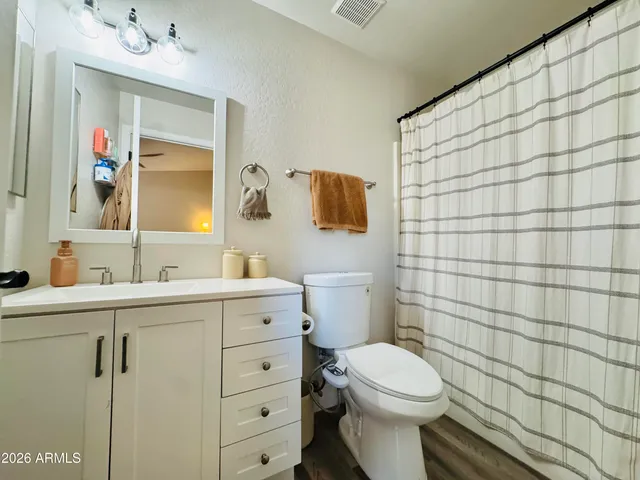 a bathroom with a toilet sink vanity and mirror