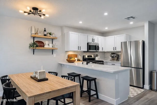 a kitchen with refrigerator cabinets and wooden floor