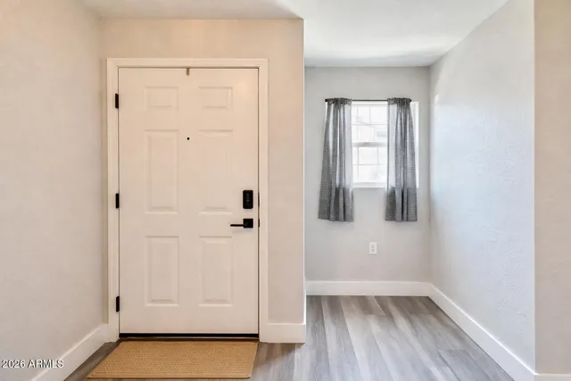 an empty room with wooden floor and mirror