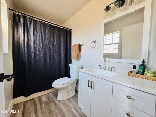 a bathroom with a sink a toilet and a mirror