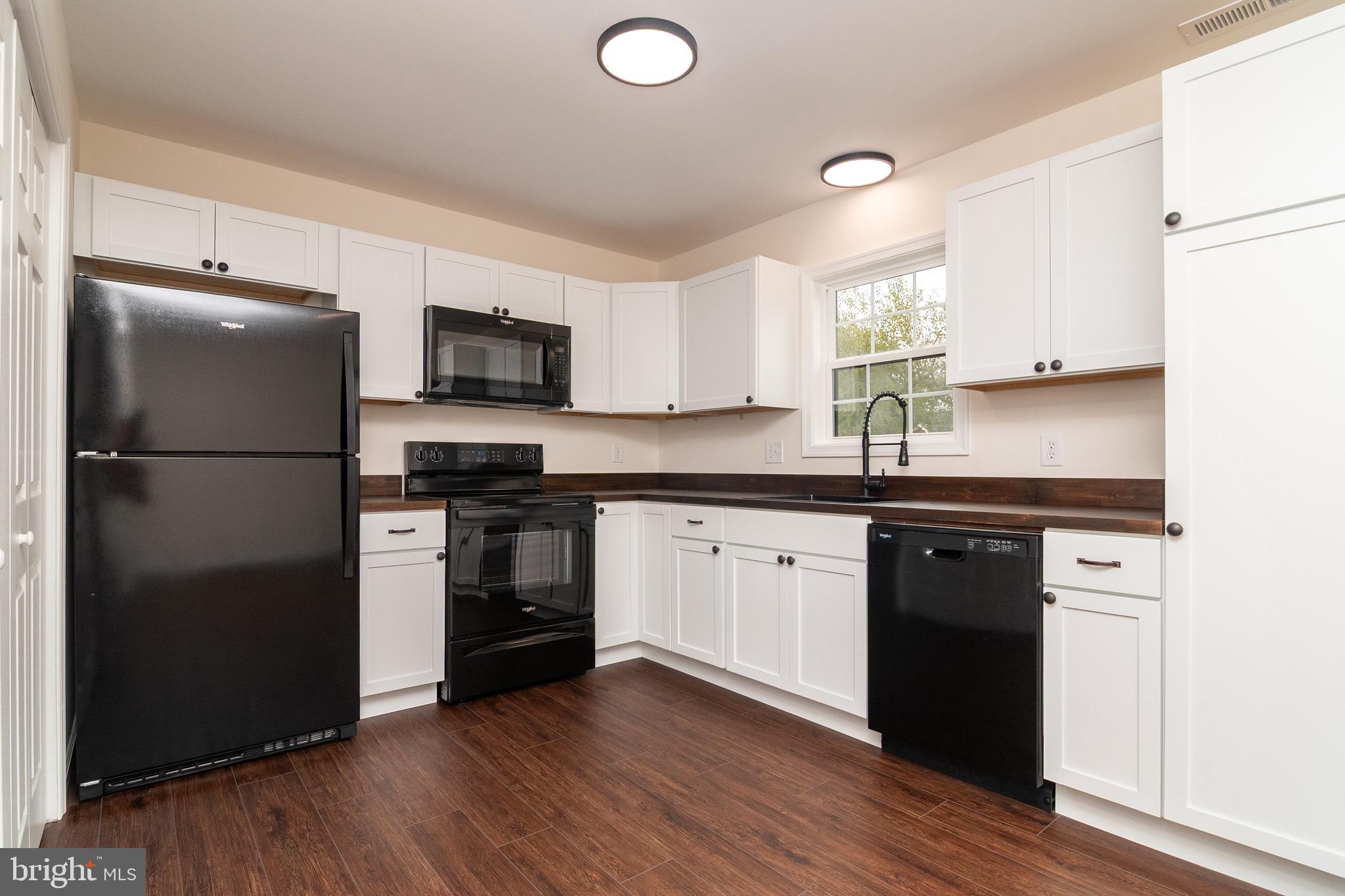 105 East Adams Street Georgetown, DE 19947 - Photo 13 of 49 a kitchen with granite countertop a refrigerator stove top oven and sink