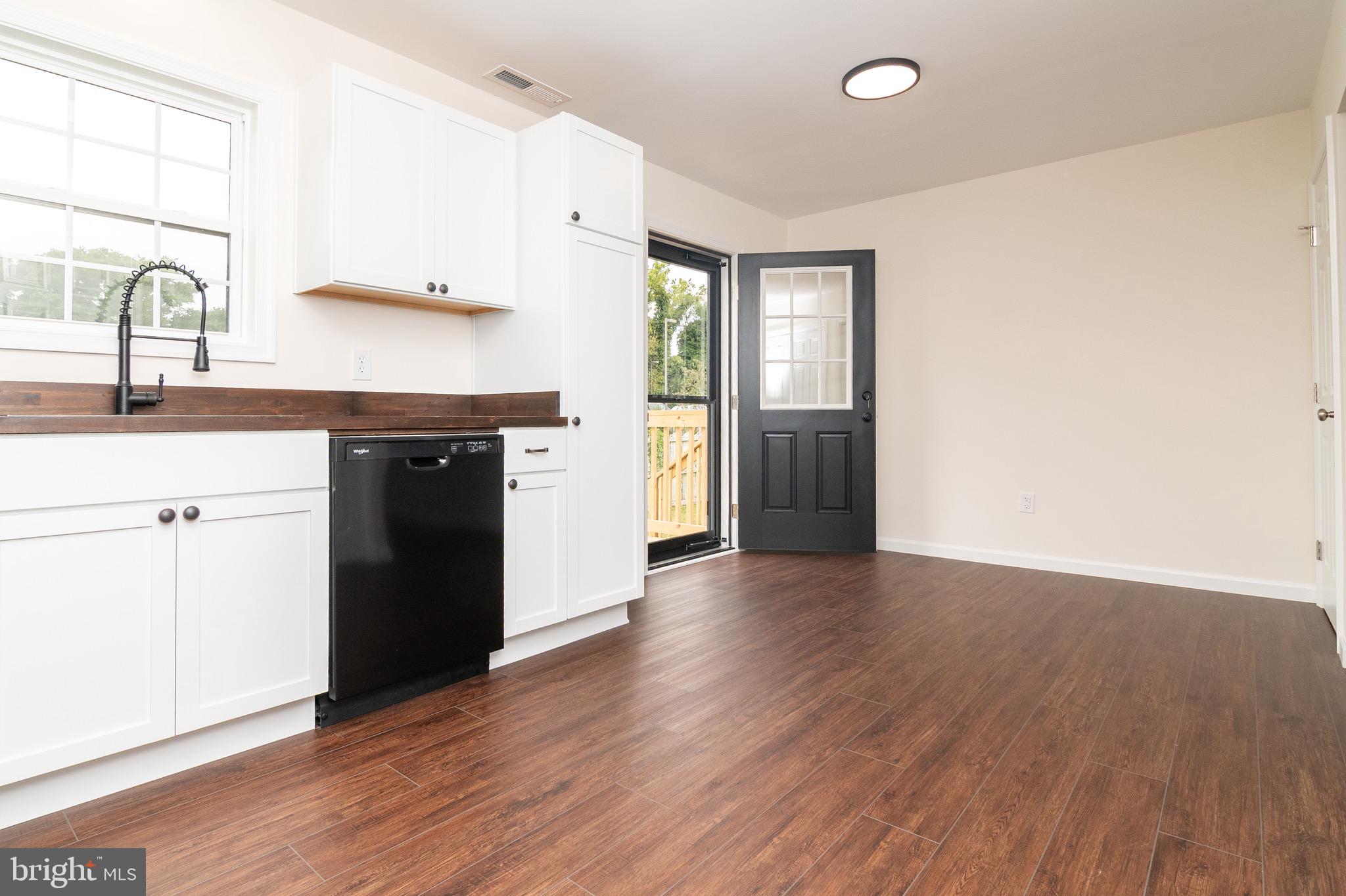 105 East Adams Street Georgetown, DE 19947 - Photo 14 of 49 a kitchen with wooden floors and refrigerator