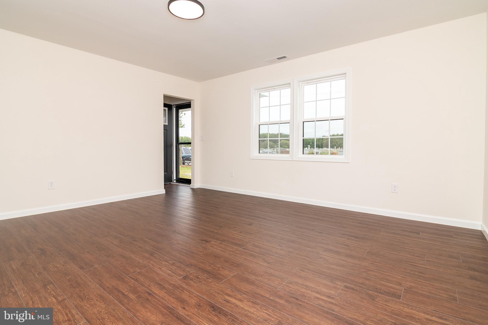 105 East Adams Street Georgetown, DE 19947 - Photo 18 of 49 an empty room with wooden floor and windows