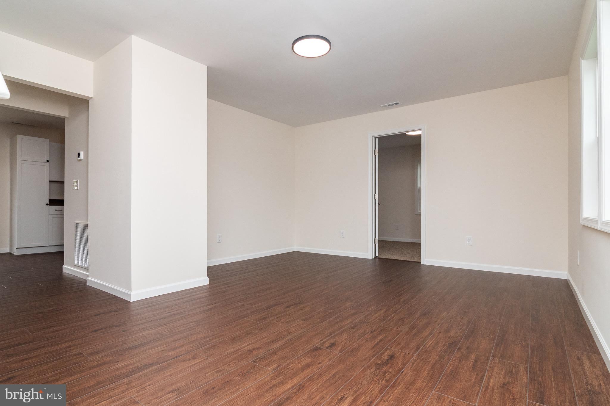 105 East Adams Street Georgetown, DE 19947 - Photo 28 of 49 an empty room with wooden floor and windows