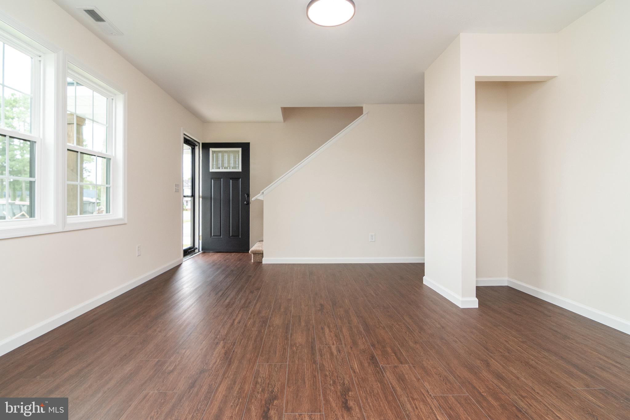 105 East Adams Street Georgetown, DE 19947 - Photo 30 of 49 an empty room with wooden floor and windows
