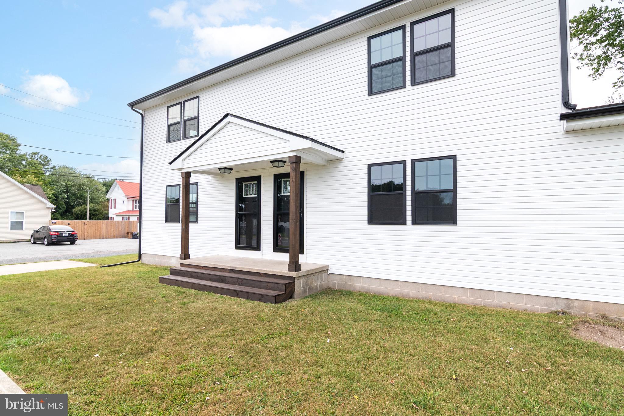 105 East Adams Street Georgetown, DE 19947 - Photo 3 of 49 a view of a white house with small yard plants and large tree