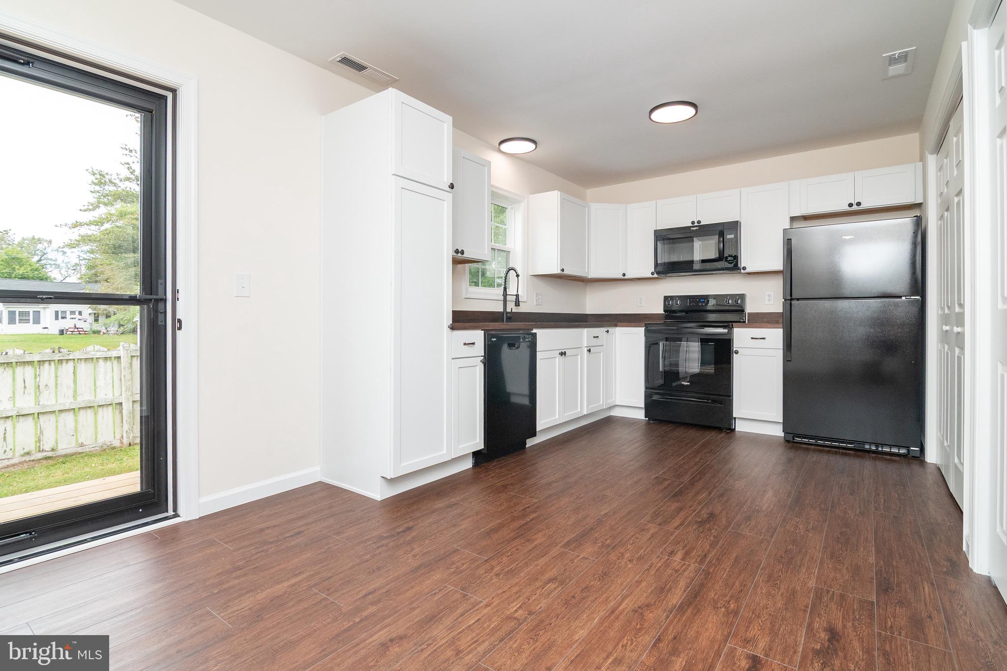 105 East Adams Street Georgetown, DE 19947 - Photo 36 of 49 a kitchen with stainless steel appliances granite countertop a stove a sink and a refrigerator