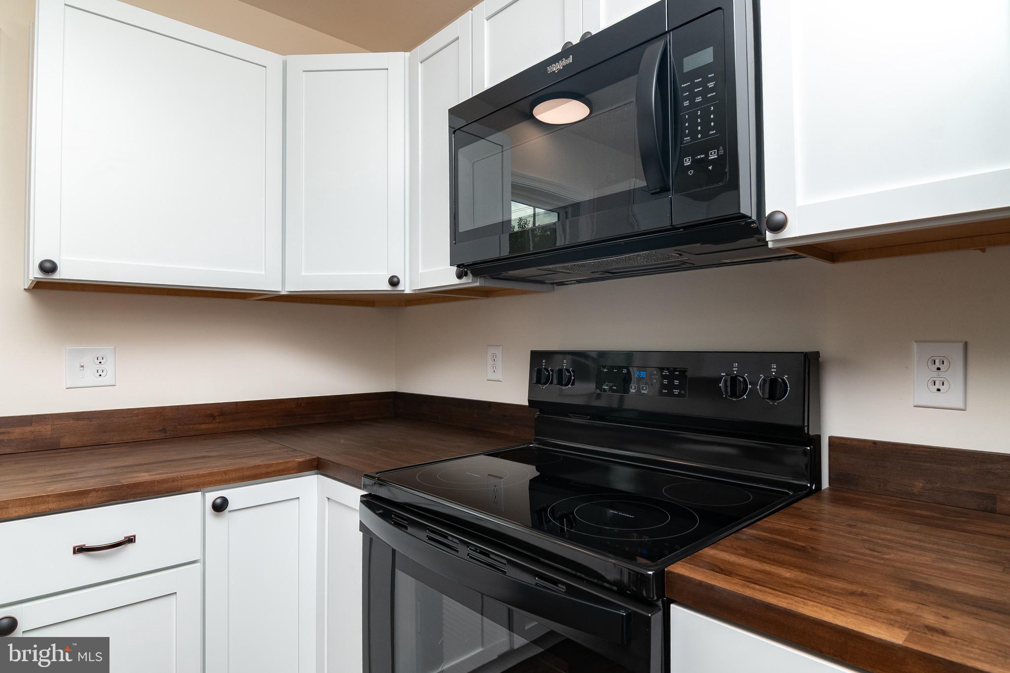 105 East Adams Street Georgetown, DE 19947 - Photo 40 of 49 a kitchen with wooden cabinets and a stove top oven
