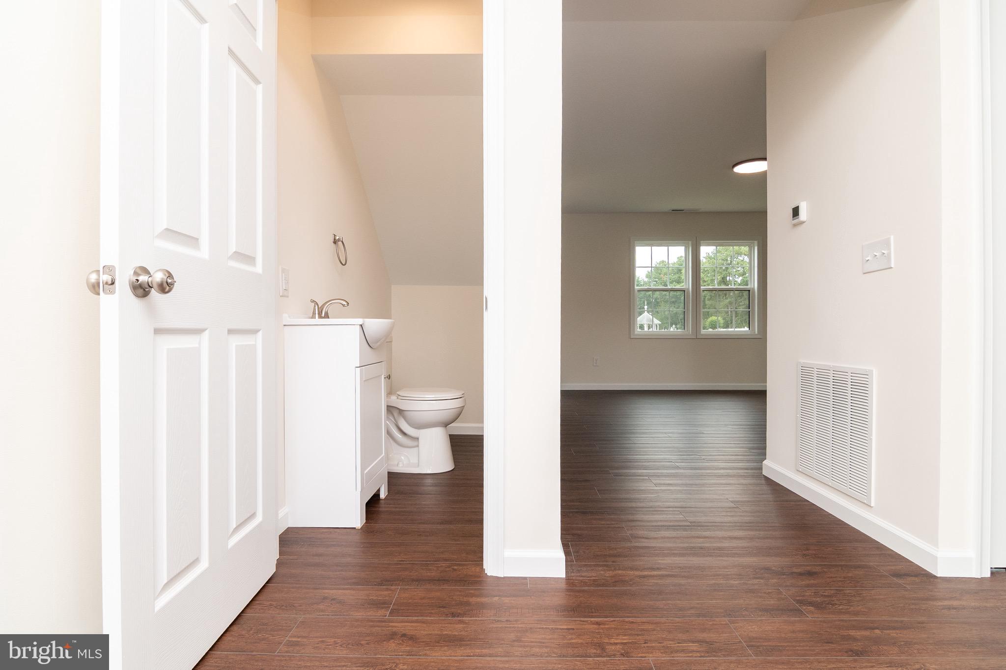 105 East Adams Street Georgetown, DE 19947 - Photo 10 of 49 a view of a hallway with wooden floor and a bathroom