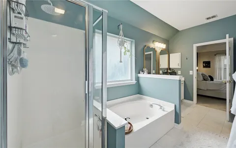 a en suite bathroom with a tub sink and mirror