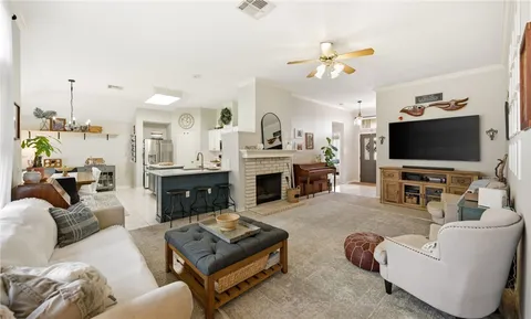 a living room with furniture a fireplace and a flat screen tv