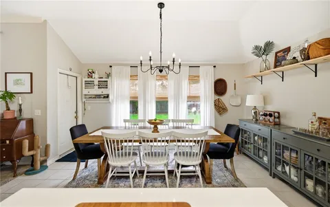 a dining room with furniture a chandelier and wooden floor