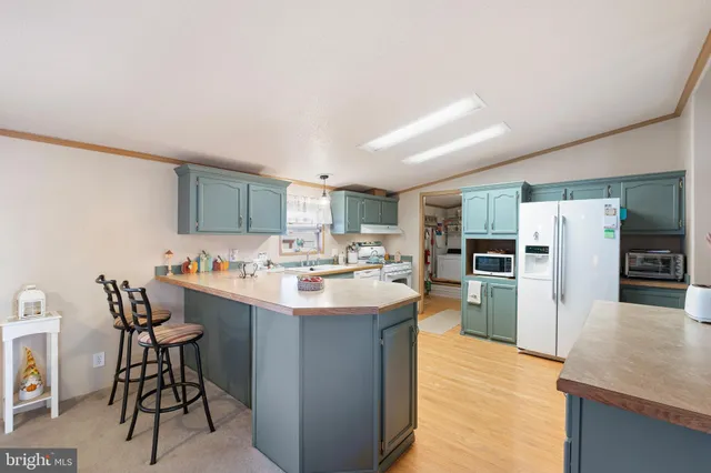 a kitchen with refrigerator and chairs