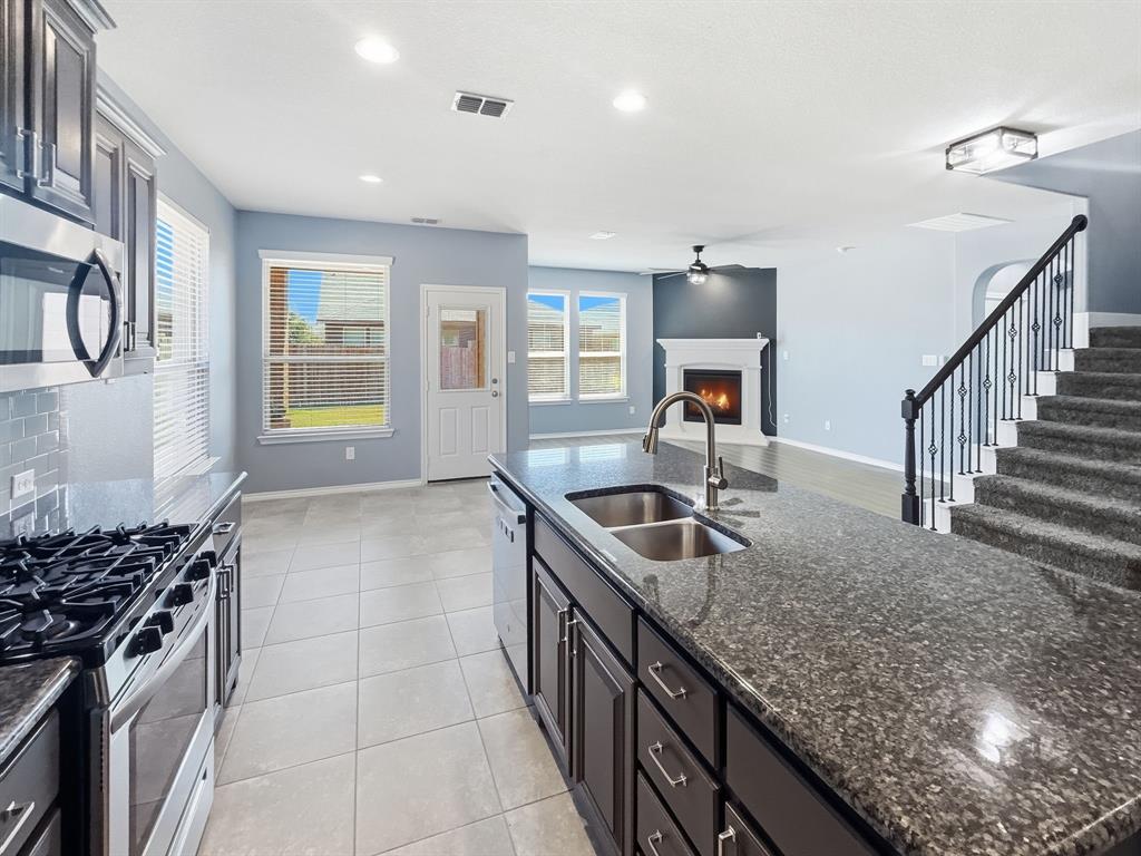 a kitchen with granite countertop a sink a stove and cabinets