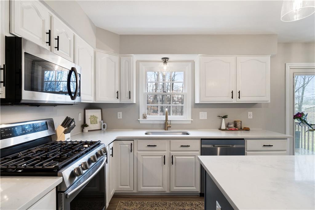 528 Pine Bluff Drive Mars, PA 16046 - Photo 11 of 25 a kitchen with stainless steel appliances a sink a stove a microwave cabinets and a window