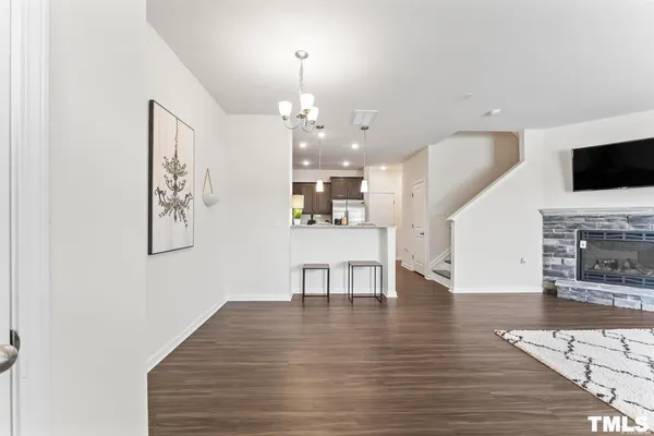 a view of a dining room with furniture a fireplace and wooden floor