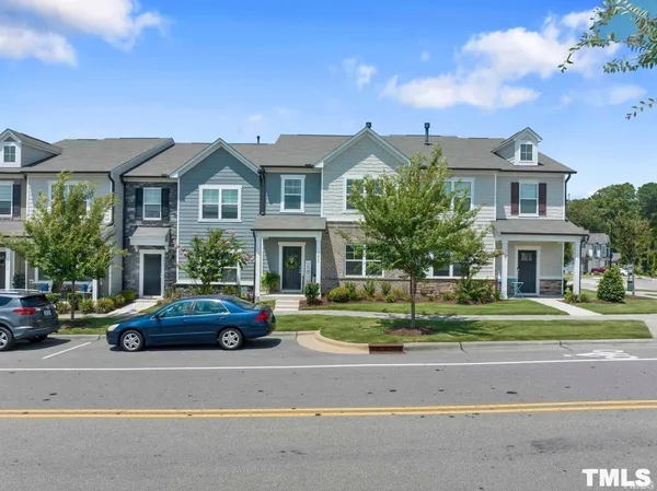 a front view of a house with a garden and parking