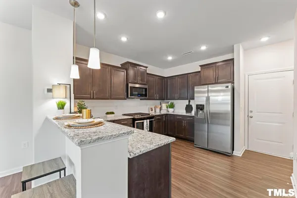 a kitchen with stainless steel appliances granite countertop a sink stove and refrigerator
