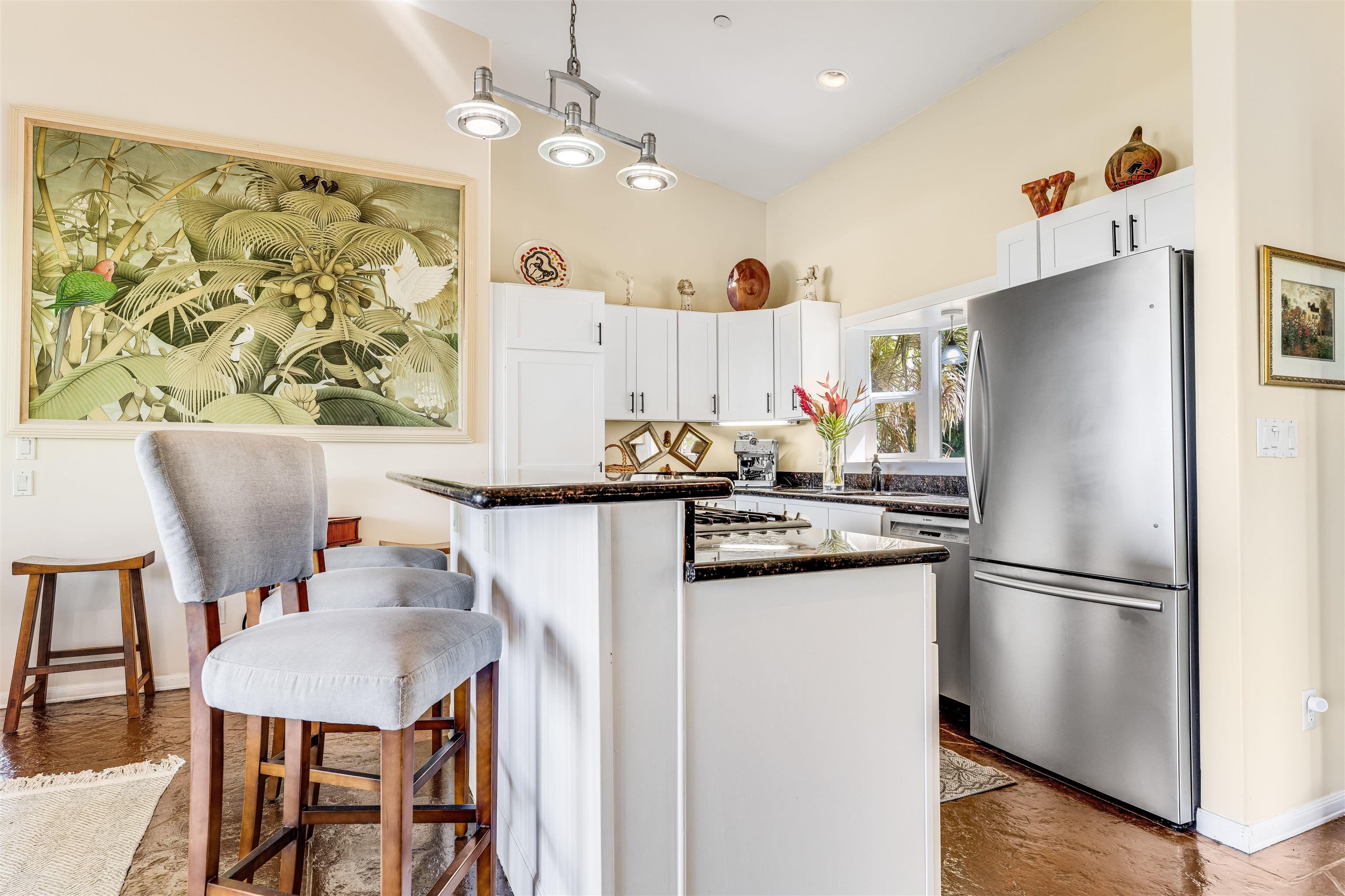 1004 North Honokala Road, Unit B Haiku, HI 96708 - Photo 23 of 49 a kitchen with stainless steel appliances granite countertop a refrigerator a sink a stove a dining table and chairs with wooden floor