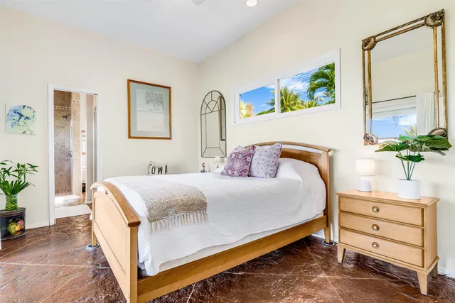 a bed sitting in a bedroom next to a window