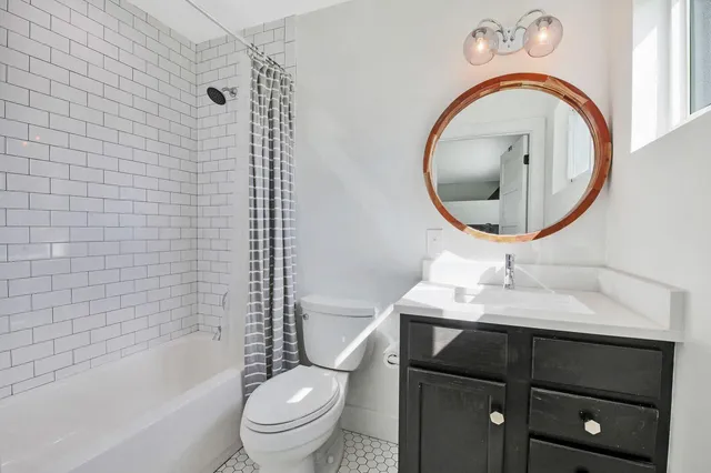 a bathroom with a sink a toilet and a mirror