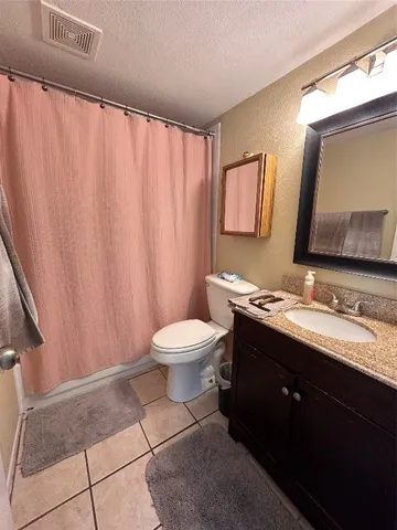 a bathroom with a granite countertop sink toilet and a mirror