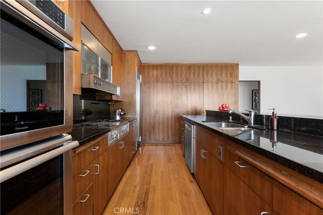 a kitchen with stainless steel appliances a sink stove top oven and cabinets
