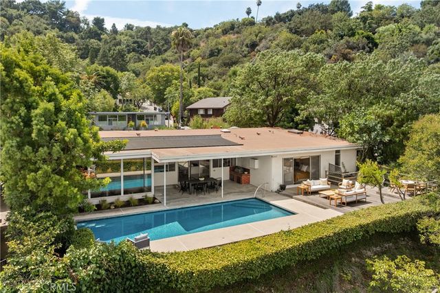 a view of a house with pool and chairs