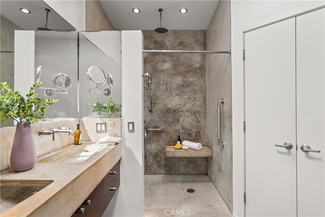 a bathroom with a granite countertop sink a mirror and shower