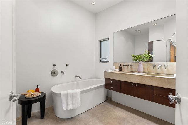 a bathroom with a tub sink and mirror