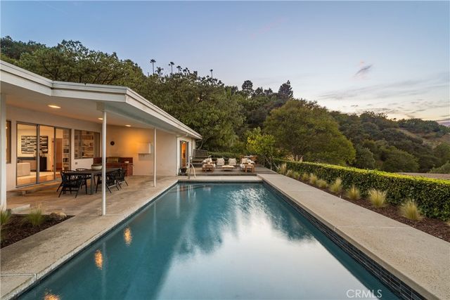 a view of a house with pool and sitting area