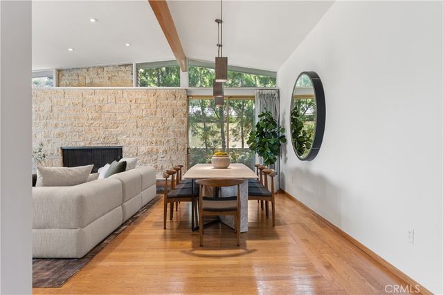 a living room with furniture a fireplace and a floor to ceiling window