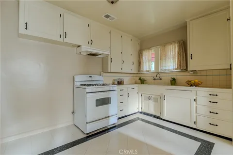 a kitchen with granite countertop white cabinets and white appliances