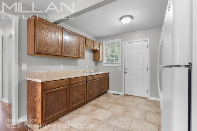 a kitchen with a refrigerator a sink and cabinets