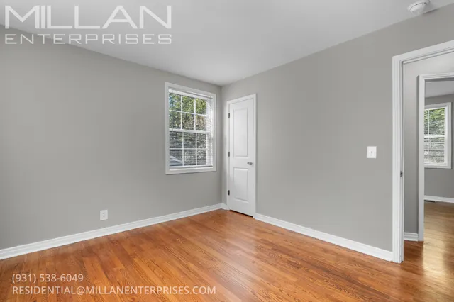 a view of an empty room with wooden floor