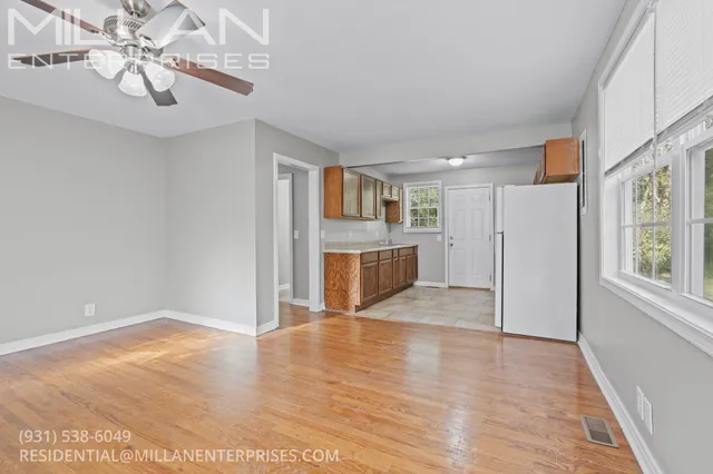 a view of empty room with wooden floor and window