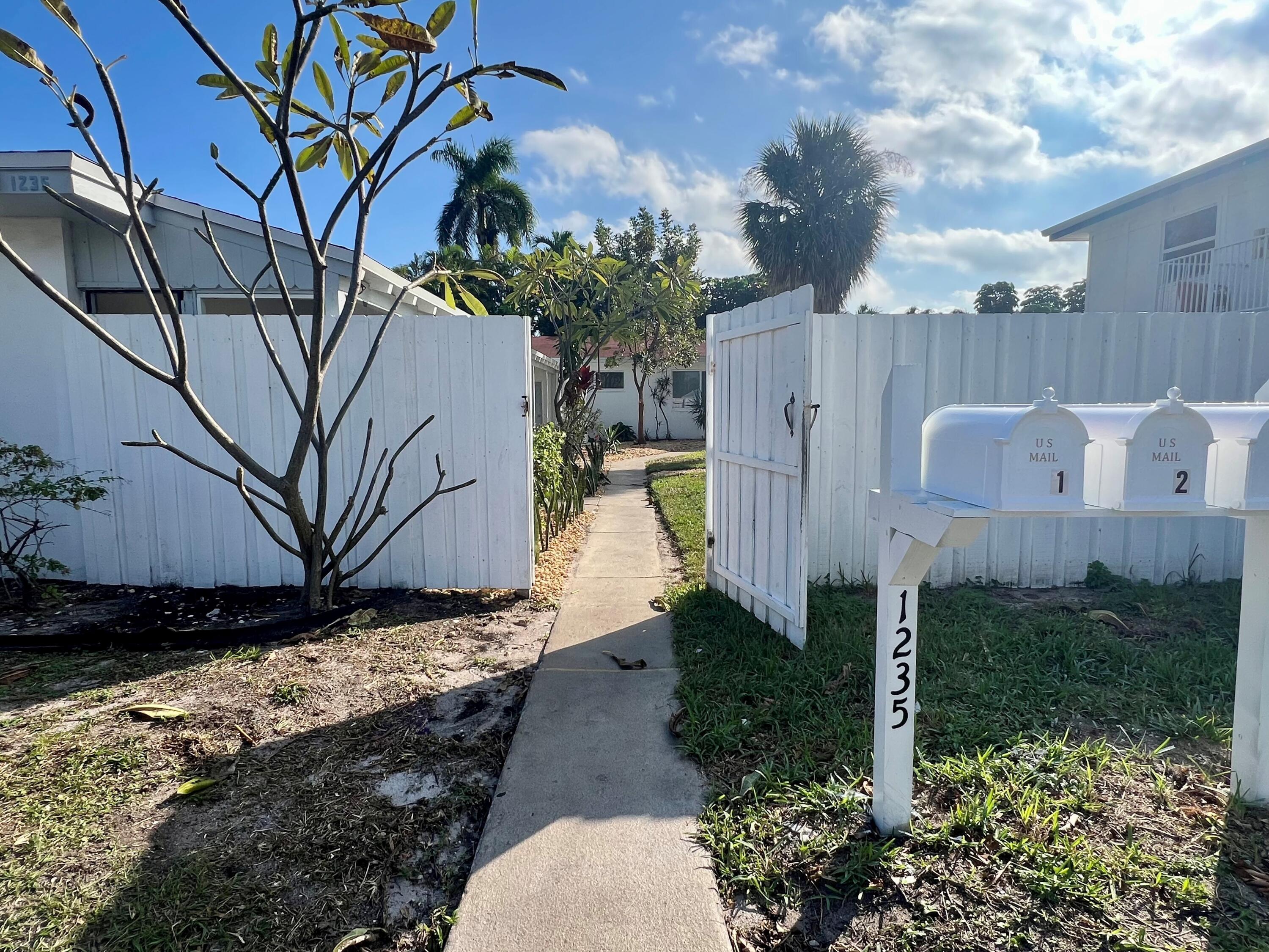 1235 Beach Road, Unit 4 Singer Island, FL 33404 - Photo 2 of 13 a backyard of a house with lots of green space