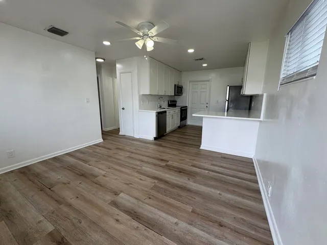 a view of kitchen with cabinets appliances and wooden floor