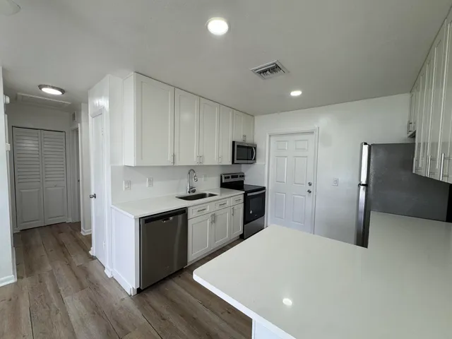 a kitchen with stainless steel appliances a refrigerator sink and stove