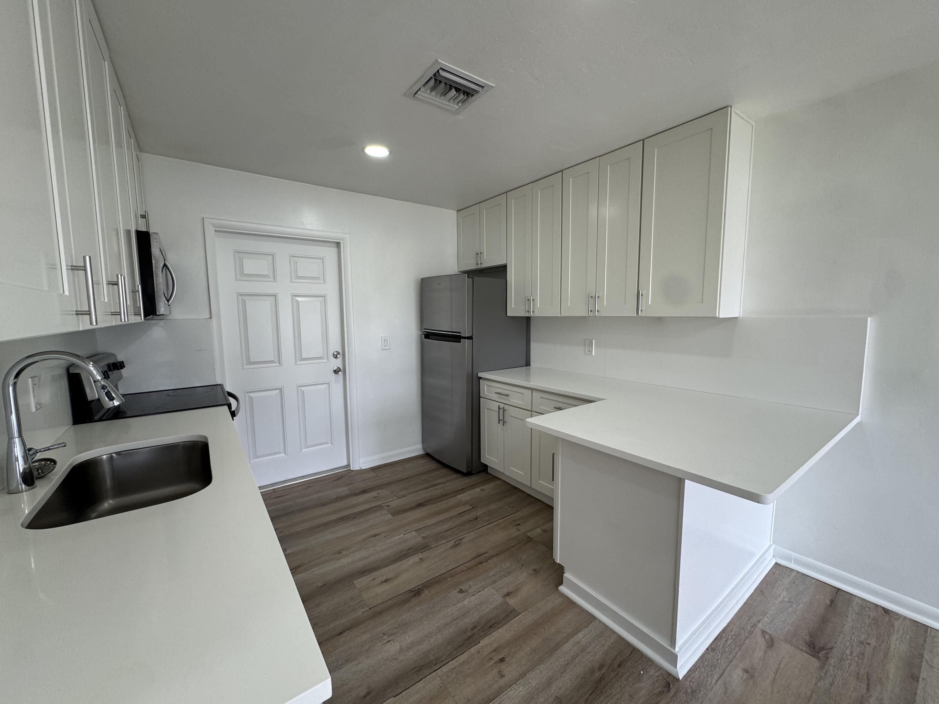 1235 Beach Road, Unit 4 Singer Island, FL 33404 - Photo 9 of 13 a kitchen with a sink a stove and refrigerator