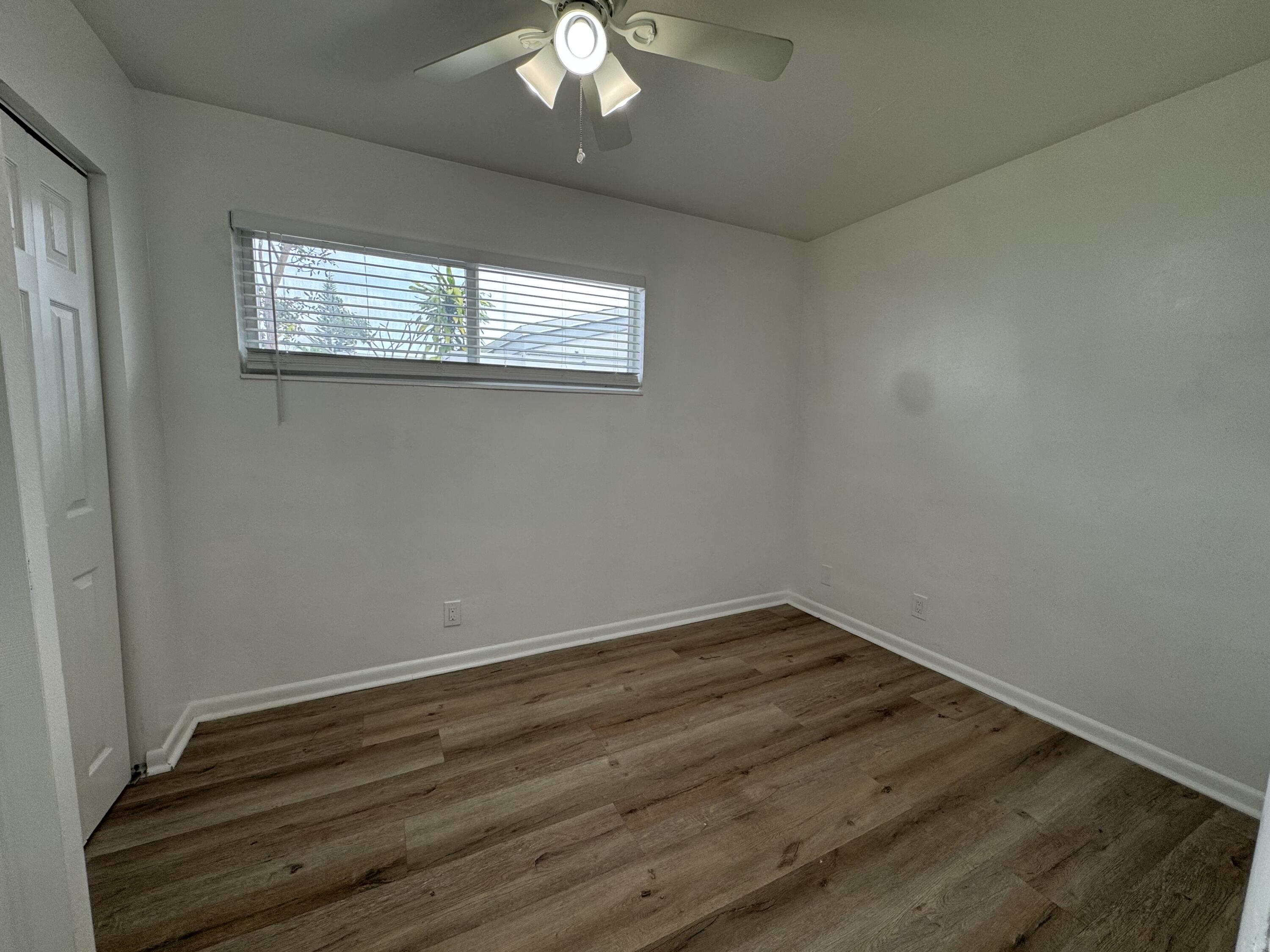 1235 Beach Road, Unit 4 Singer Island, FL 33404 - Photo 10 of 13 an empty room with wooden floor and windows