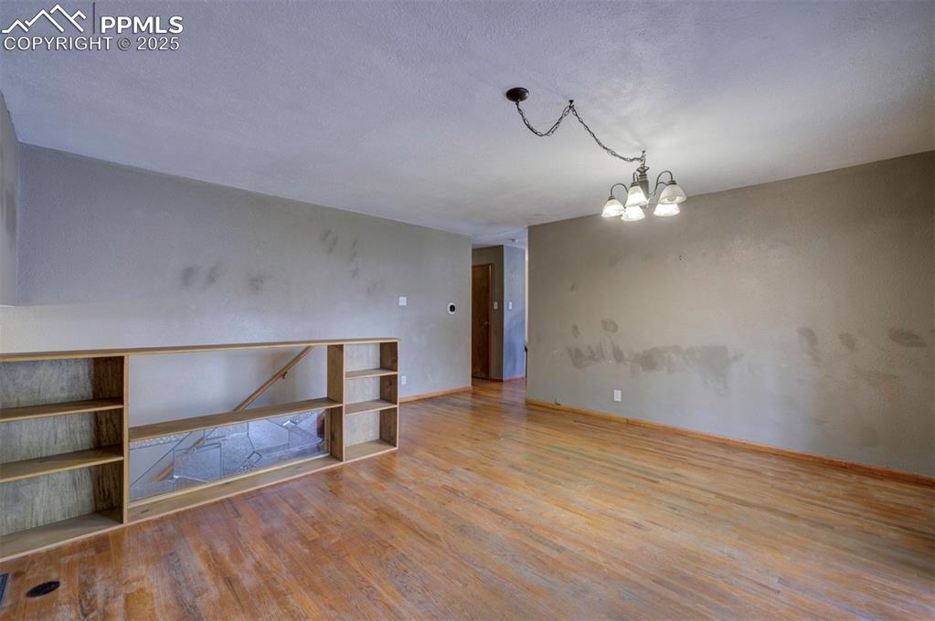 61 Louis Nelson Road Pueblo, CO 81001 - Photo 16 of 50 wooden floor in an empty room with a chandelier