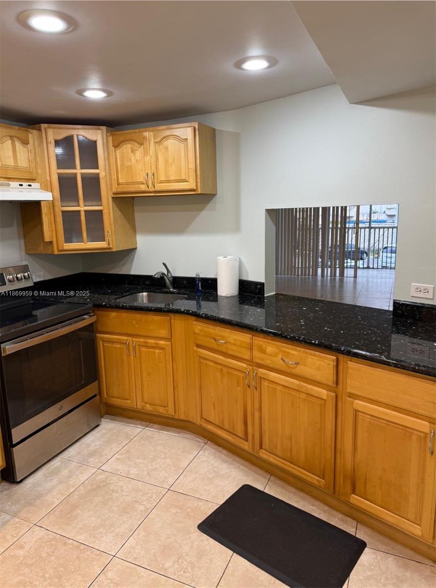 1710 Northeast 191st Street, Unit 2083 Miami, FL 33179 - Photo 15 of 36 a kitchen with stainless steel appliances granite countertop a stove a sink and a microwave