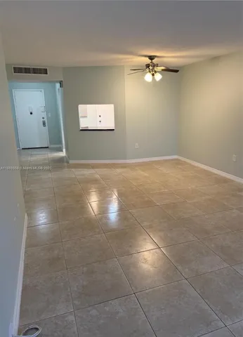 a view of a big room with a ceiling fan and entryway