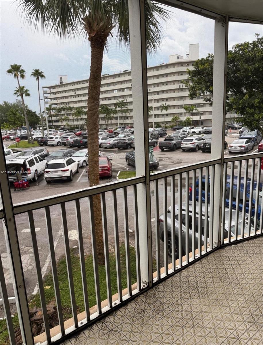 1710 Northeast 191st Street, Unit 2083 Miami, FL 33179 - Photo 21 of 36 a view of balcony with floor to ceiling windows and wooden fence