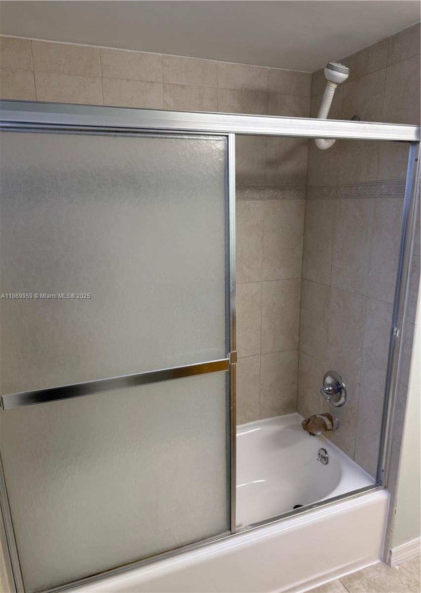 1710 Northeast 191st Street, Unit 2083 Miami, FL 33179 - Photo 30 of 36 a bathroom with a bathtub and a shower
